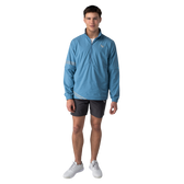 Man wearing a blue jacket and gray shorts on a white background
