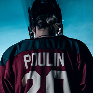 MP Poulin in hockey uniform with back turned to camera