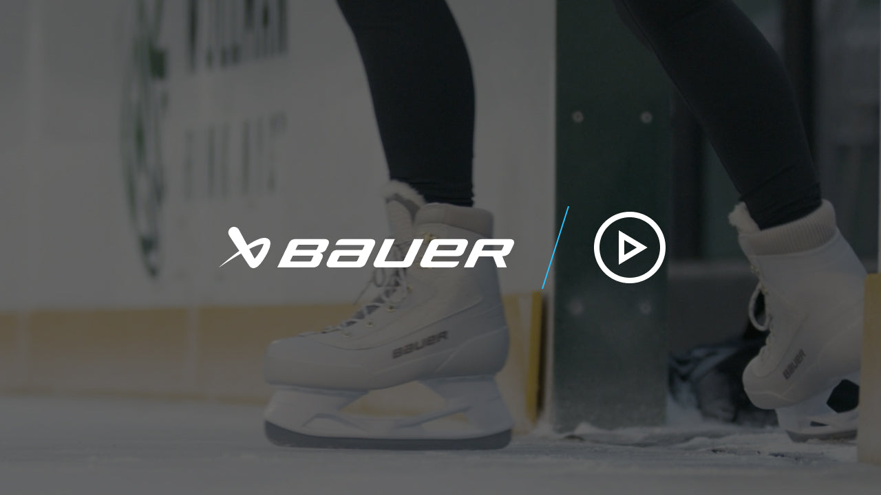 close up on a pair of white ice skates gliding out onto the ice