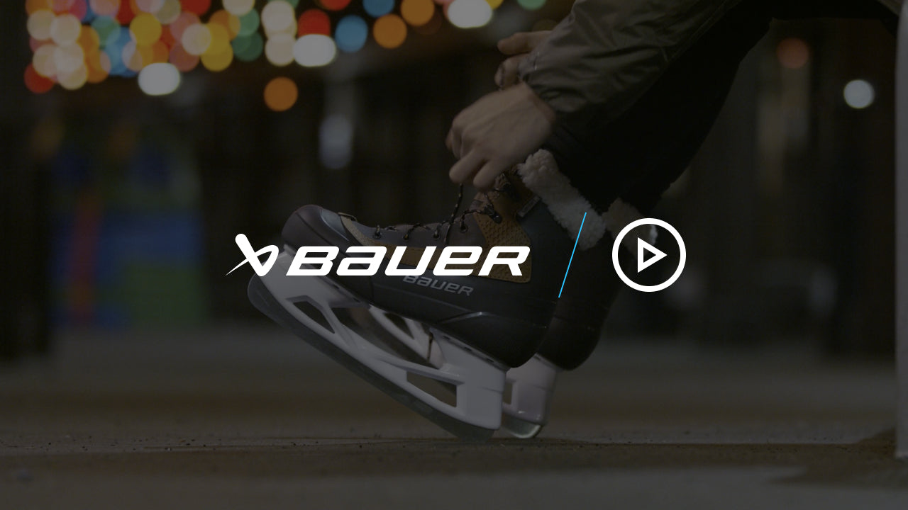 lacing up brown and tan ice skates on a bench next to an outdoor rink